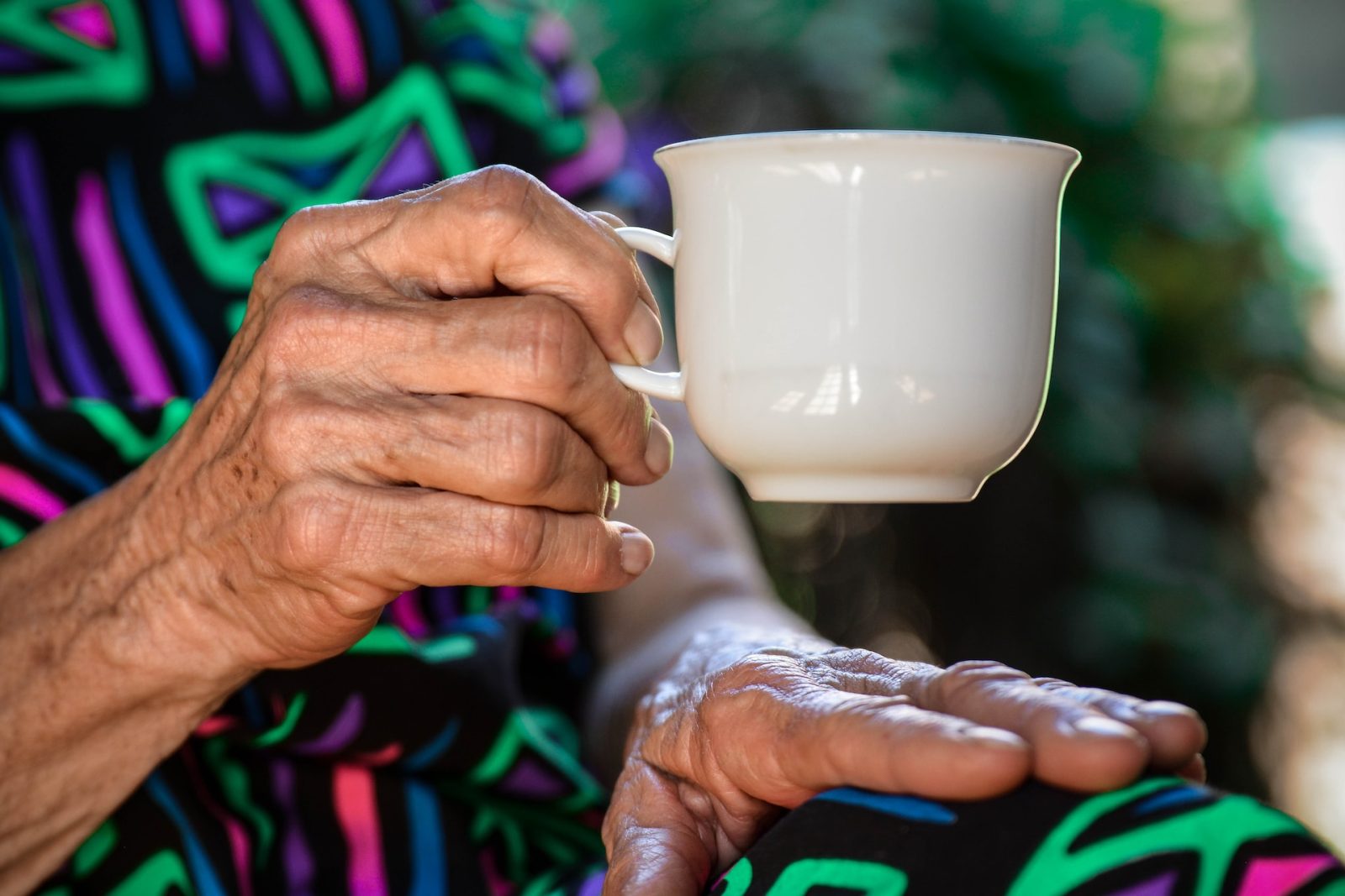 Ältere Frau hält Tasse in der Hand